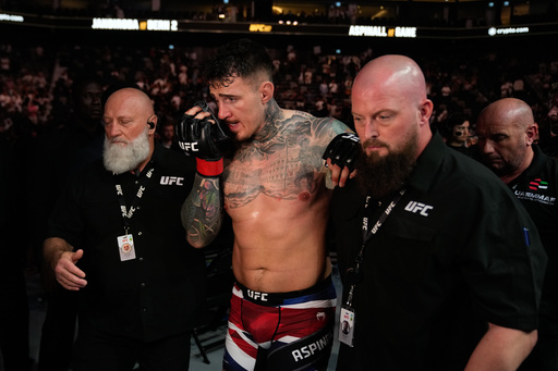 England's Tom Aspinall leaves after the fight was called off when his eyes were poked by Ciryl Gane of France during the heavyweight title bout at the UFC mixed martial arts Fight Night in Abu Dhabi, United Arab Emirates, Saturday, Oct. 25, 2025. (AP Photo/Altaf Qadri) England's Tom Aspinall leaves after the fight was called off when his eyes were poked by Ciryl Gane of France during the heavyweight title bout at the UFC mixed martial arts Fight Night in Abu Dhabi, United Arab Emirates, Saturday, Oct. 25, 2025. (AP Photo/Altaf Qadri)