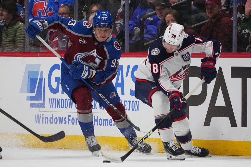 Columbus Blue Jackets defenseman Damon Severson, right, collects the puck as Colorado Avalanche center Zakhar Bardakov defends in the first period of an NHL hockey game Saturday, Jan. 10, 2026, in Denver. (AP Photo/David Zalubowski)