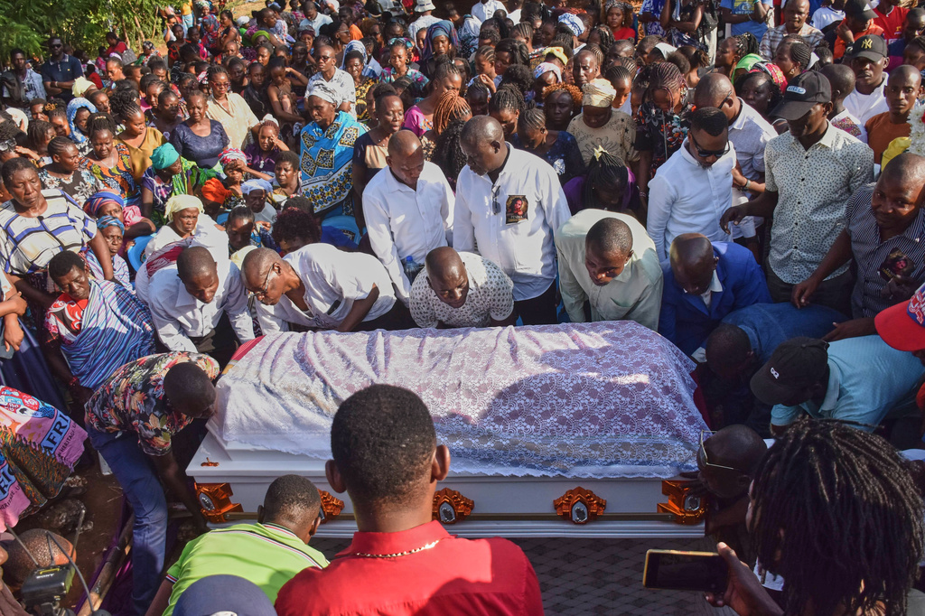Mourners gather as the casket of 29 years old Penina Zawadi, who died from complications while giving birth, is lowered into her grave during her funeral in Kilifi County, Kenya, Saturday, July 18, 2026. (AP Photo/Brian Wachira)