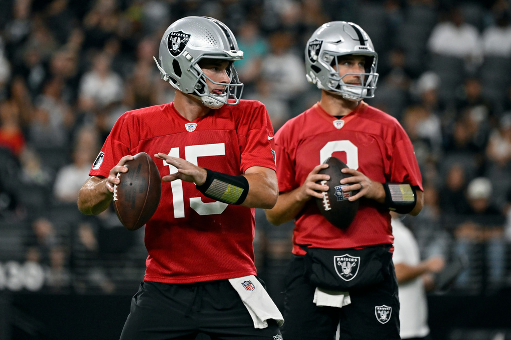Las Vegas Raiders quarterbacks Fernando Mendoza (15) and Kirk Cousins (8) participate during an NFL football practice Tuesday, Aug. 11, 2026, in Las Vegas. (AP Photo/David Becker)