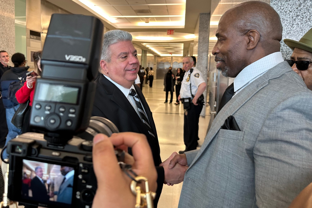Kenneth Windley, right, shakes hands with Brooklyn District Attorney Eric Gonzalez at the courthouse in the Brooklyn borough of New York, Monday, March 16, 2026. (AP Photo/Jennifer Peltz)
