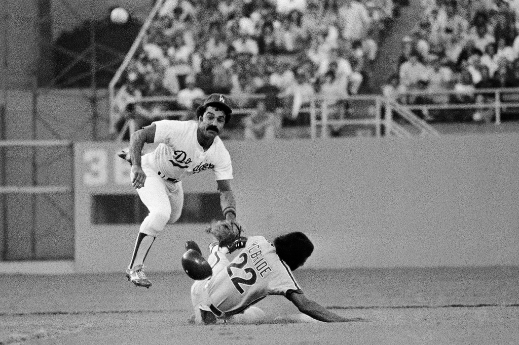 FILE - Los Angeles Dodgers second baseman Davey Lopes goes flying after forcing out Philadelphias Phillies Bake McBride in the front end of a double play hit into by Philadelphia's larry Bowa in the first inning of a baseball game, Oct. 4, 1977, in Los Angeles.. (AP Photo/File)
