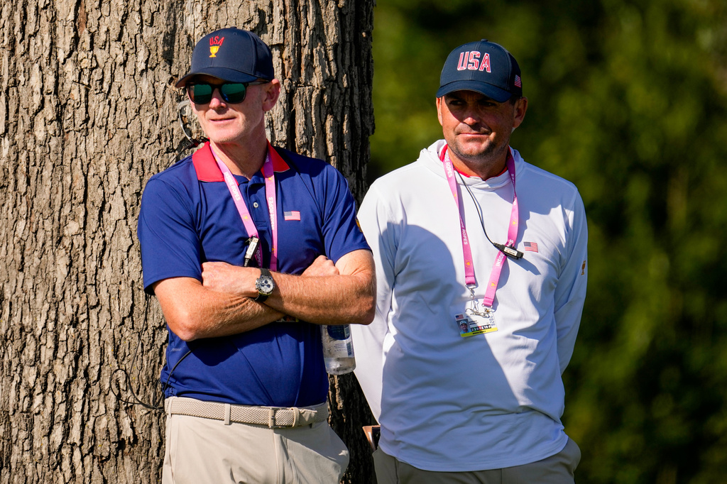 USA team captain Brandt Snedeker, left, and assistant Keegan Bradley watch play on the 12th green against the International team during a Presidents Cup golf tournament third round four-ball match at Medinah Country Club, Saturday, Sept. 26, 2026, in Medinah, Ill. (AP Photo/Matt Slocum)