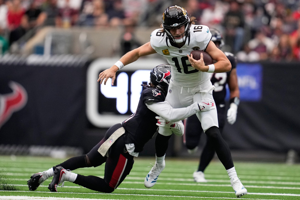 Houston Texans cornerback Tremon Smith (11) tackles Jacksonville Jaguars quarterback Trevor Lawrence (16) during an NFL football game, Sunday, Nov. 9, 2025, in Houston. (AP Photo/Ashley Landis)