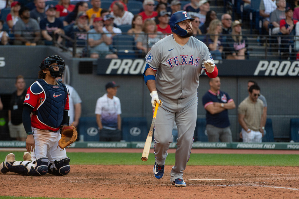 Texas Rangers' Rowdy Tellez, right, watches his three-run home run off Cleveland Guardians relief pitcher Zak Kent as Guardians catcher Bo Naylor, left, looks on during the 10th inning of a baseball game, Sunday, Sept. 28, 2025, in Cleveland. (AP Photo/Phil Long)
