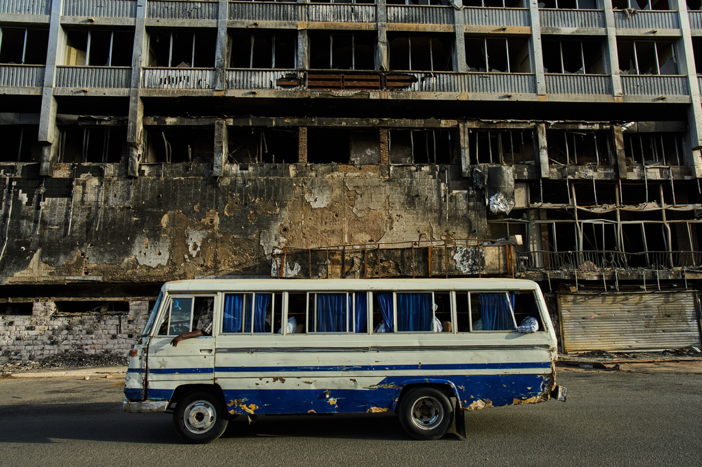 A bus drives past a hotel destroyed during the war in downtown Khartoum, Sudan, Sunday, April 19, 2026. (AP Photo/Bernat Armangue)