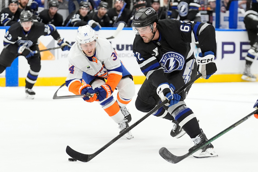 Tampa Bay Lightning center Jack Finley (62) cuts in front of New York Islanders defenseman Adam Boqvist (34) during the second period of an NHL hockey game Saturday, Dec. 6, 2025, in Tampa, Fla. (AP Photo/Chris O'Meara)