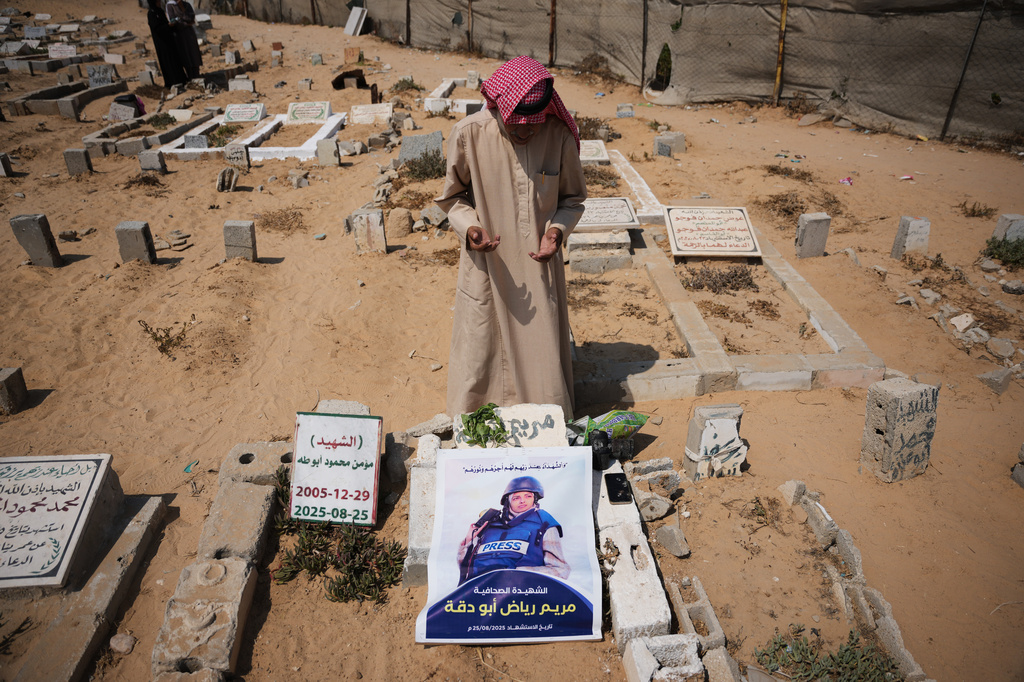 Riyad Abu Dagga, 69, visits the grave of his daughter, Mariam Dagga, a freelance journalist who worked with The Associated Press and other news outlets during the Gaza war and was killed in an Israeli airstrike on the Nasser Hospital building in Khan Younis on Aug. 25, 2025, at a cemetery in Khan Younis, Gaza Strip, Aug. 16, 2026. (AP Photo/Abdel Kareem Hana)