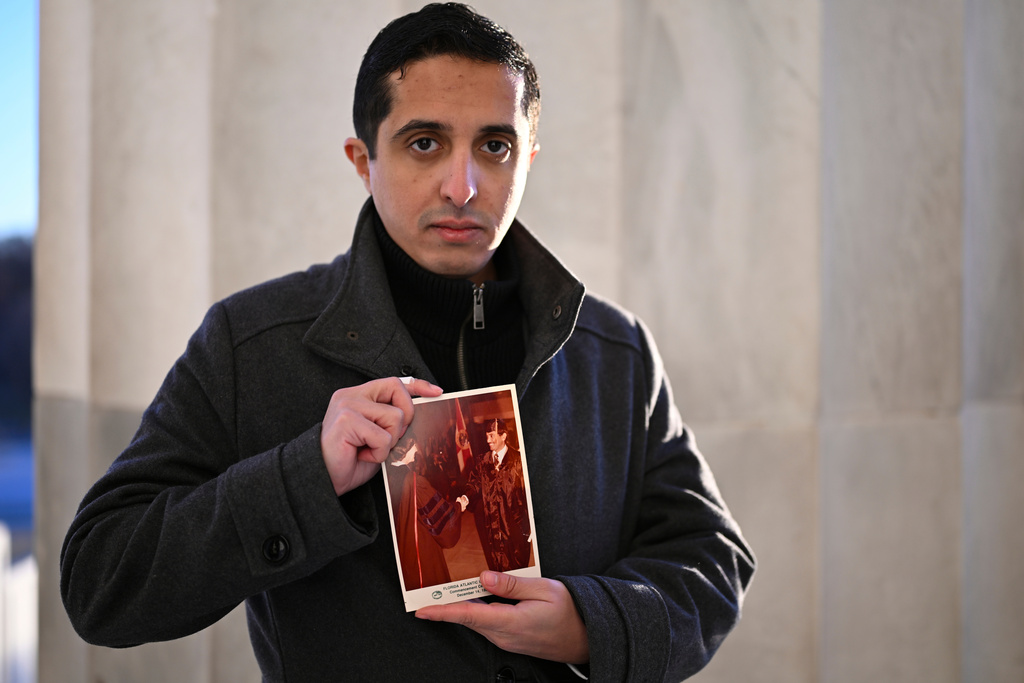 FILE - Ibrahim Almadi holds a photo of his father Saad Almadi graduating from college in 1984, in Washington, Dec. 23, 2024. (AP Photo/John McDonnell, File)