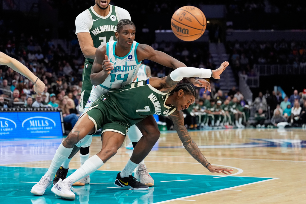 Charlotte Hornets forward Moussa Diabate vies for the ball with Milwaukee Bucks guard Kevin Porter Jr. during the first half of an NBA basketball game, Monday, Dec. 29, 2025, in Charlotte, N.C. (AP Photo/Chris Carlson)