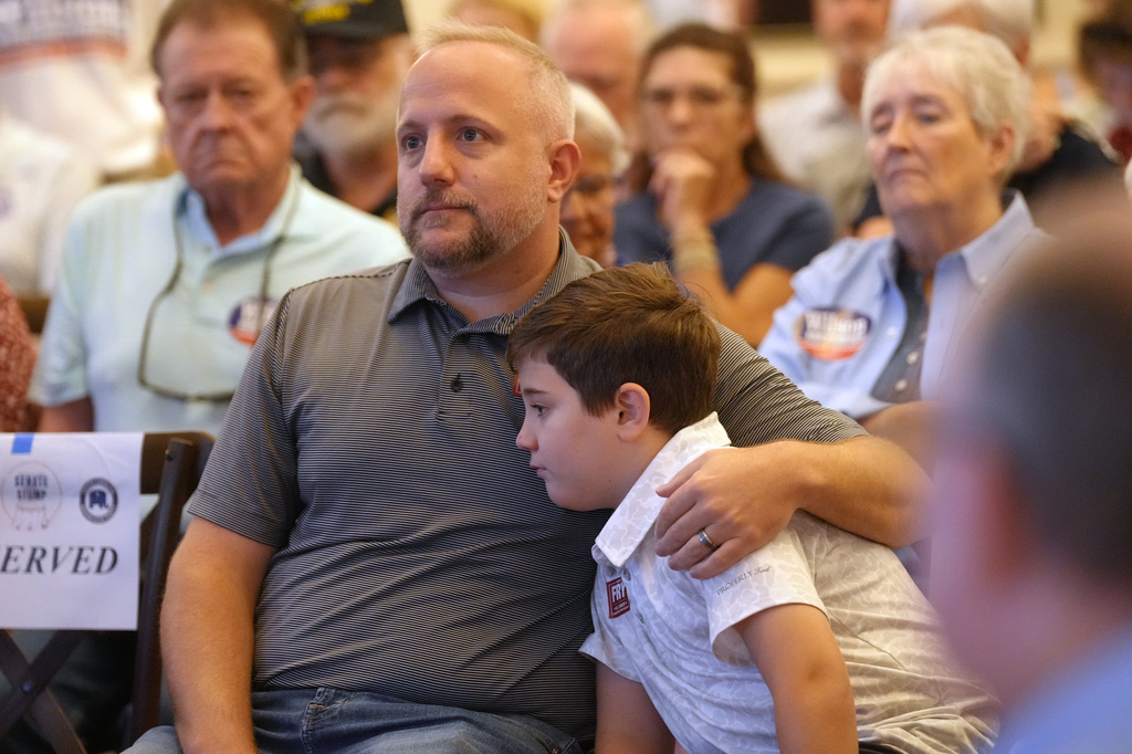 Rep. Russell Fry, R-S.C., left, sits with his son James at a candidate event for hopefuls vying in a special Republican primary to replace the late Sen. Lindsey Graham, R-S.C., on November ballots, Saturday, Aug. 8, 2026, in Florence, S.C. (AP Photo/Meg Kinnard)