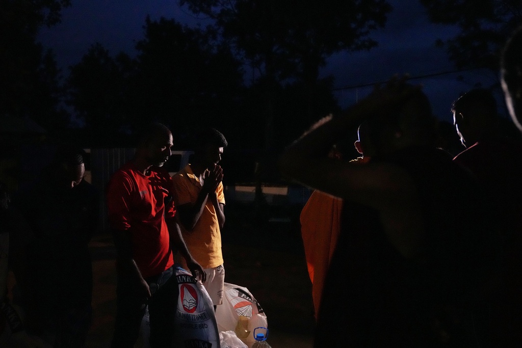 Displaced tea plantation workers from Cyclone Ditwah that led to floods and landslides express gratitude after receiving relief items from local residents at a safety center at Craighead Estate in Nawalapitiya, Sri Lanka, Thursday, Dec. 11, 2025. (AP Photo/Eranga Jayawardena)