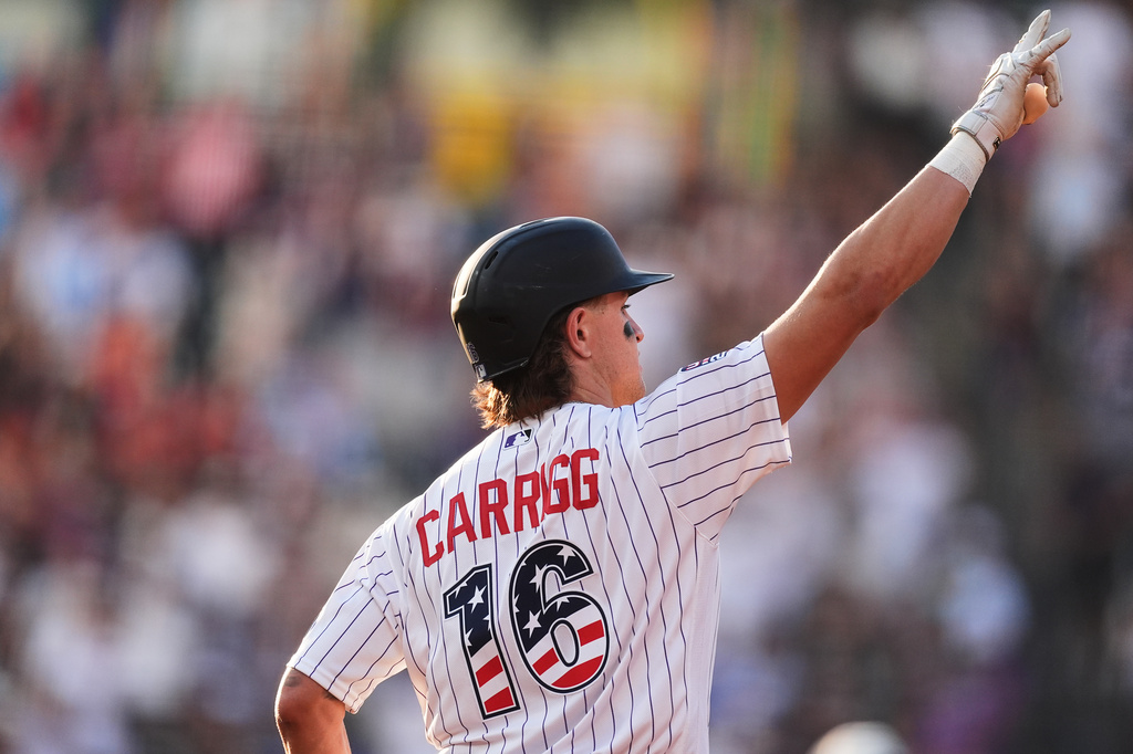 Colorado Rockies' Cole Carrigg gestures to the bullpen as he circles the bases after hititng a three-run home run off San Francisco Giants starting pitcher Robbie Ray in the first inning of a baseball game Saturday, July 4, 2026, in Denver. (AP Photo/David Zalubowski)
