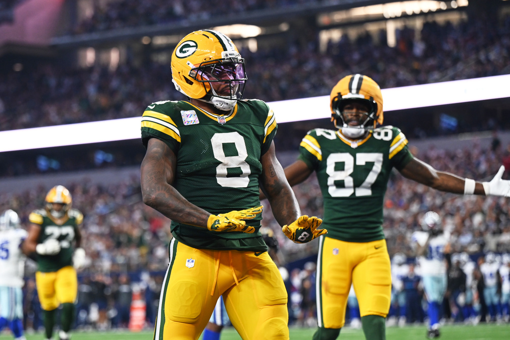 Green Bay Packers running back Josh Jacobs (8) and Romeo Doubs (87) celebrate a touchdown scored by Jacobs in the second half of an NFL football game against the Dallas Cowboys Sunday, Sept. 28, 2025, in Arlington, Texas. (AP Photo/Jessica Tobias)