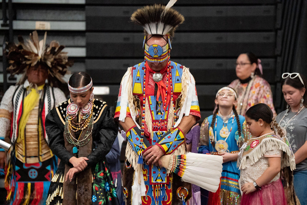 FILE - Members of the Lumbee Tribe bow their heads in prayer during the BraveNation Powwow and Gather at UNC Pembroke, March 22, 2025, in Pembroke, N.C. (AP Photo/Allison Joyce, file)