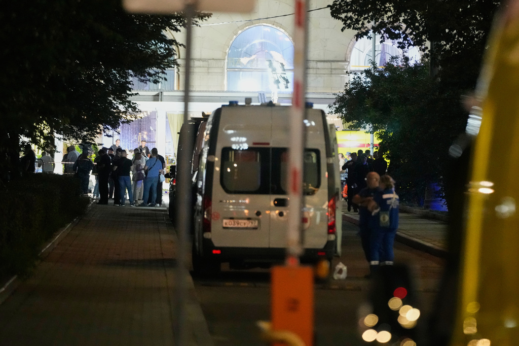 Ambulances and special services vehicles are parked near the site where an improvised explosive device detonated at a restaurant in central Moscow, Saturday, Aug. 1, 2026. (AP Photo/Pavel Bednyakov)