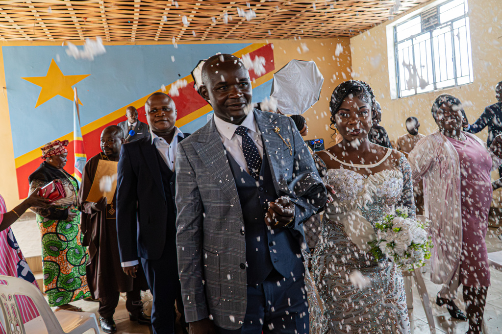 A newly married couple walks down the aisle at their wedding as guests shower them with confetti amid an Ebola outbreak in Ituri Province in Bunia, Congo, Saturday, June 6, 2026. (AP Photo/Moses Sawasawa)