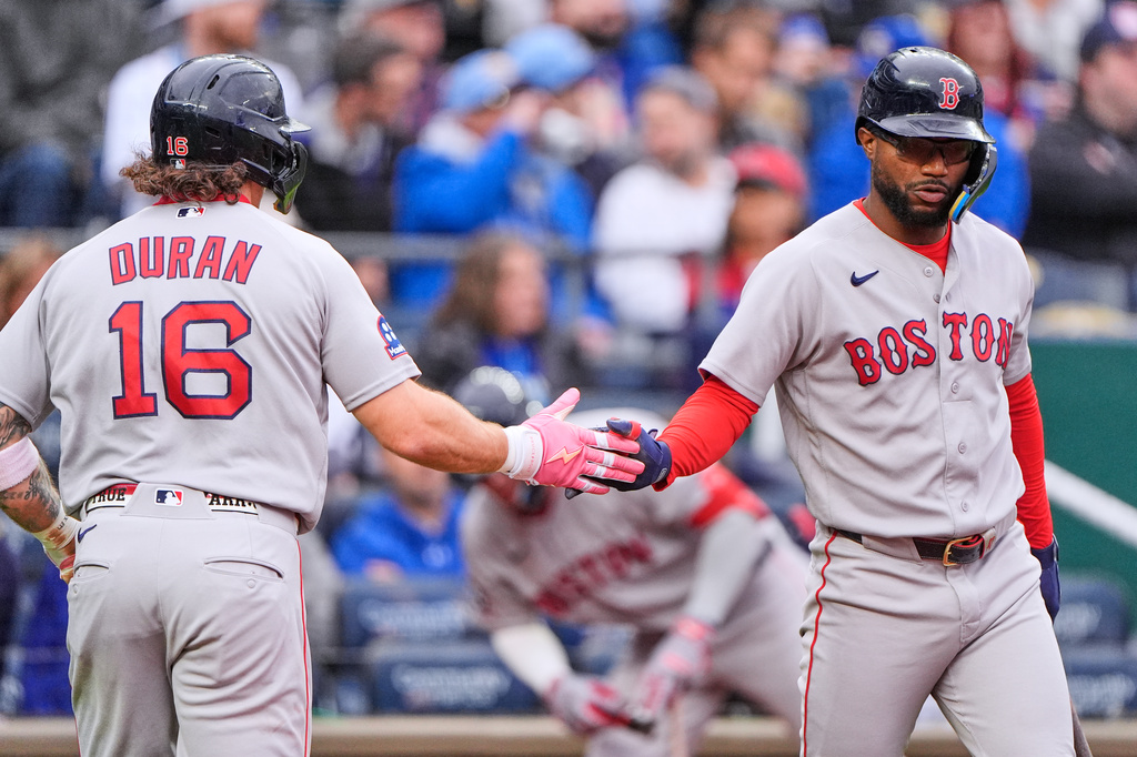 Boston Red Sox's Jarren Duran (16) celebrates with Andruw Monasterio after scoring on a single by Willson Contreras during the first inning of a baseball game against the Kansas City Royals, Tuesday, May 19, 2026, in Kansas City, Mo. (AP Photo/Charlie Riedel)