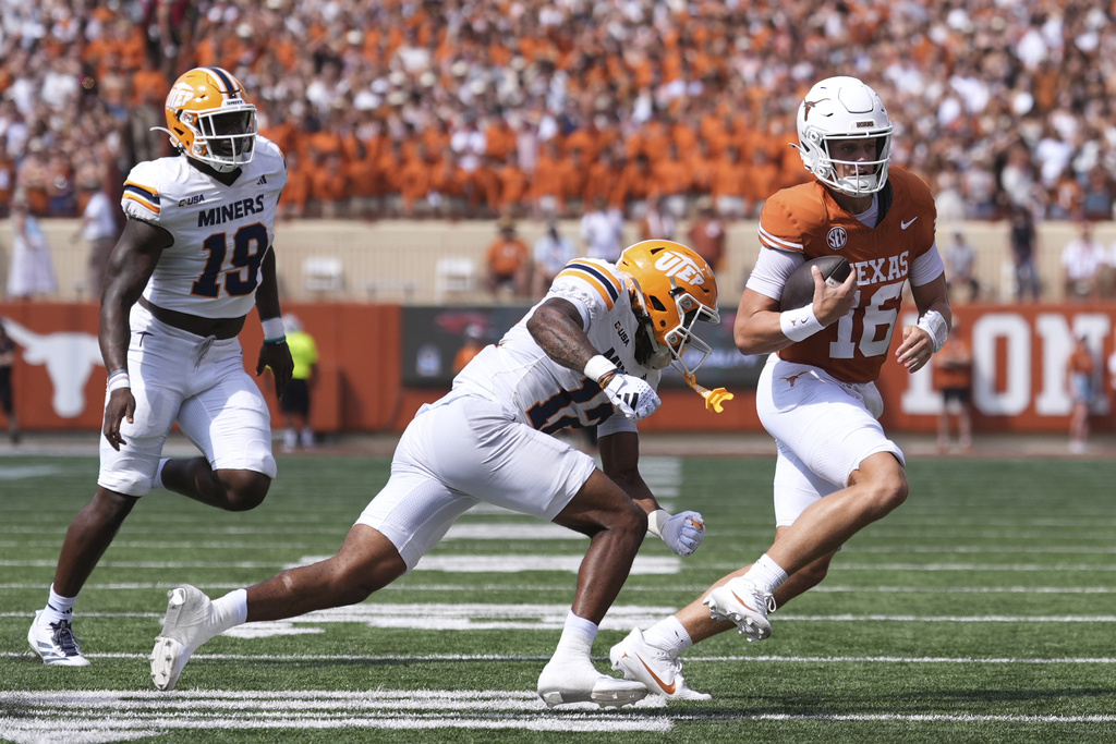 Texas quarterback Arch Manning (16) runs from UTEP linebacker Donte Thompson (12) and defensive lineman Ashaad Hall (19) during the first half of an NCAA college football game in Austin, Texas, Saturday, Sept. 13, 2025. (AP Photo/Eric Gay)