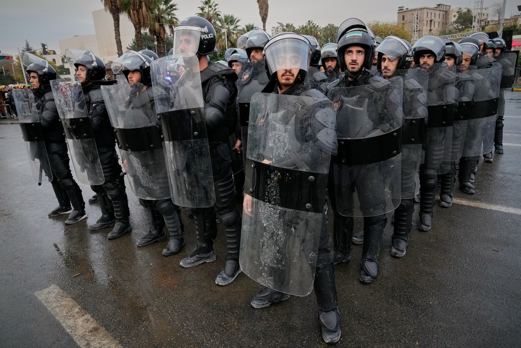 Riot police stand in formation ahead of a parade by the new Syrian army marking the first anniversary of the ousting of the Bashar Assad regime in Damascus, Syria, early Monday, Dec. 8, 2025. (AP Photo/Hussein Malla)