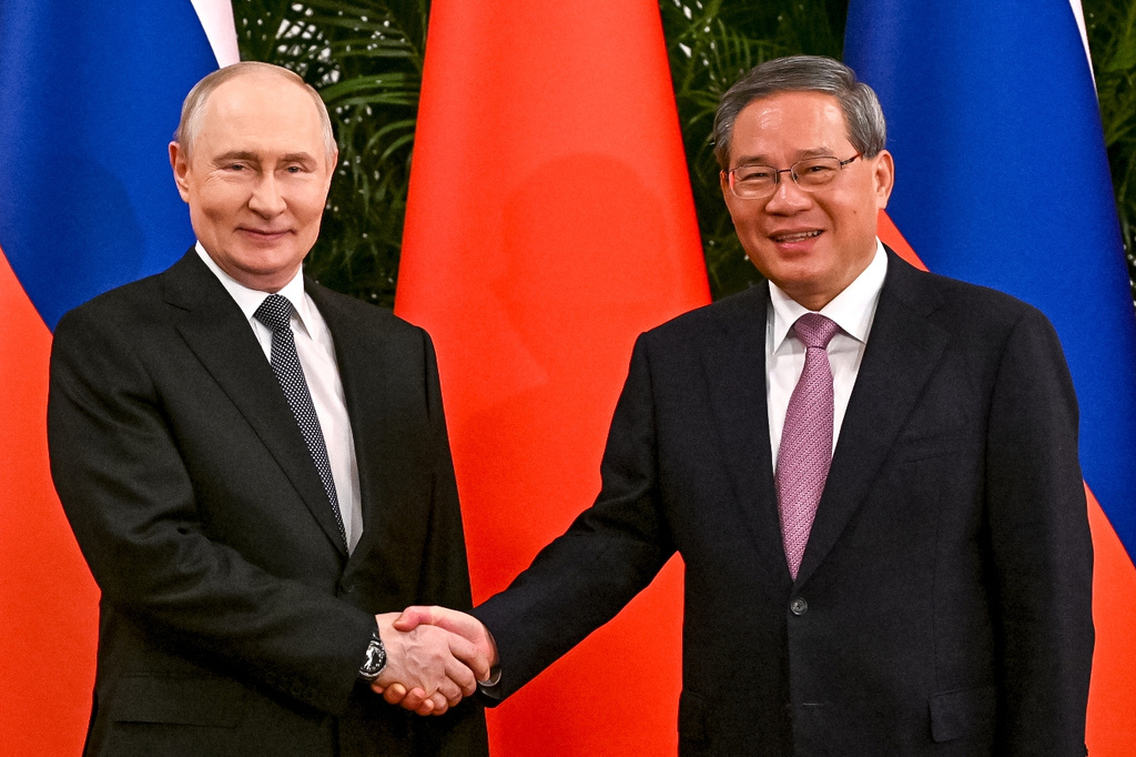 Russian President Vladimir Putin, left, and Chinese Premier Li Qiang shake hands during their meeting at the Great Hall of the People in Beijing, Wednesday, May 20, 2026. (Kristina Solovyova, Sputnik, Kremlin Pool Photo via AP)