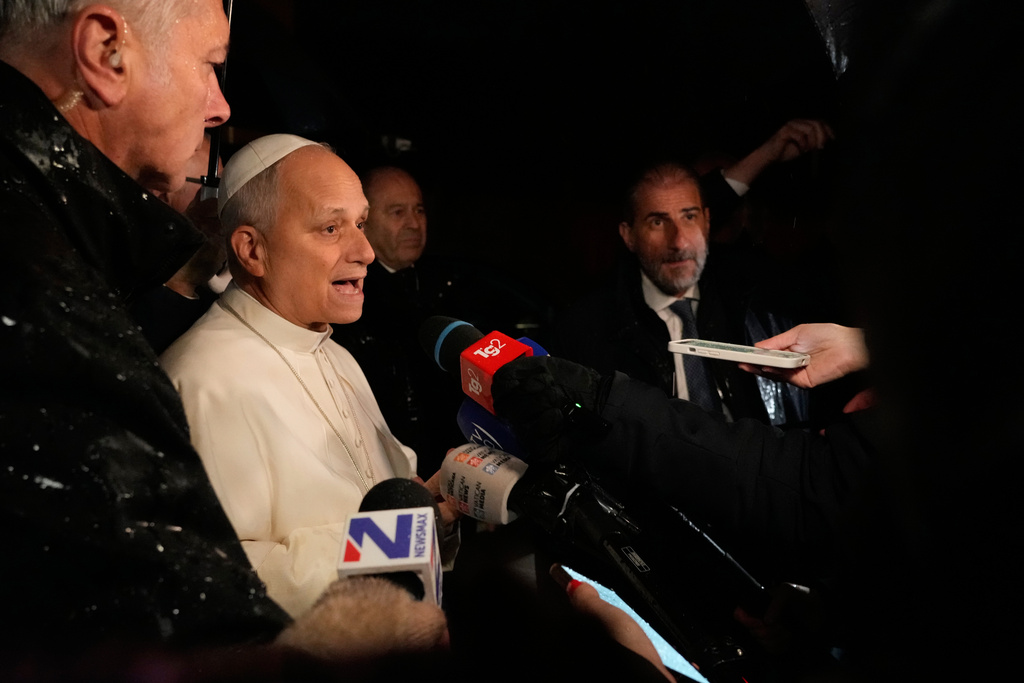 Pope Leo XIV talks to journalists as he leaves the Castel Gandolfo residence to head to the Vatican, Tuesday, Dec. 23, 2025. (AP Photo/Gregorio Borgia)