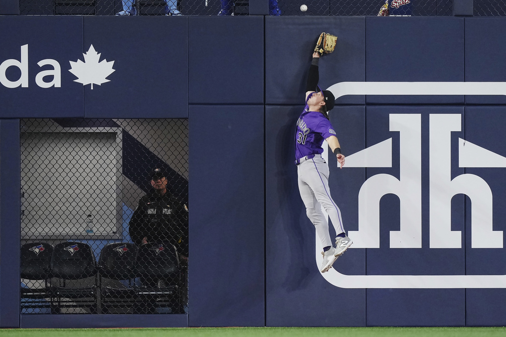 Colorado Rockies outfielder Jake McCarthy (31) can't make the catch on an RBI double by Toronto Blue Jays' Ernie Clement during the seventh inning of a baseball game in Toronto on Tuesday, March 31, 2026. (Nathan Denette/The Canadian Press via AP)