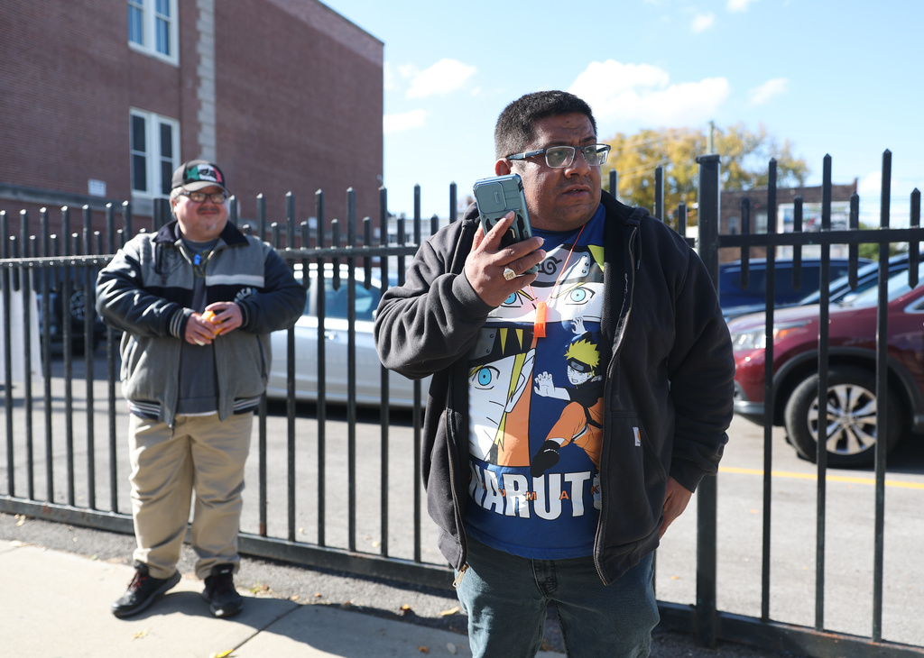 Baltazar Enriquez, president of the Little Village Community Council, speaks on the phone while patrolling for U.S. Immigration and Customs Enforcement (ICE) agents in Chicago's Little Village neighborhood, Wednesday, Oct. 29, 2025. (AP Photo/Talia Sprague)