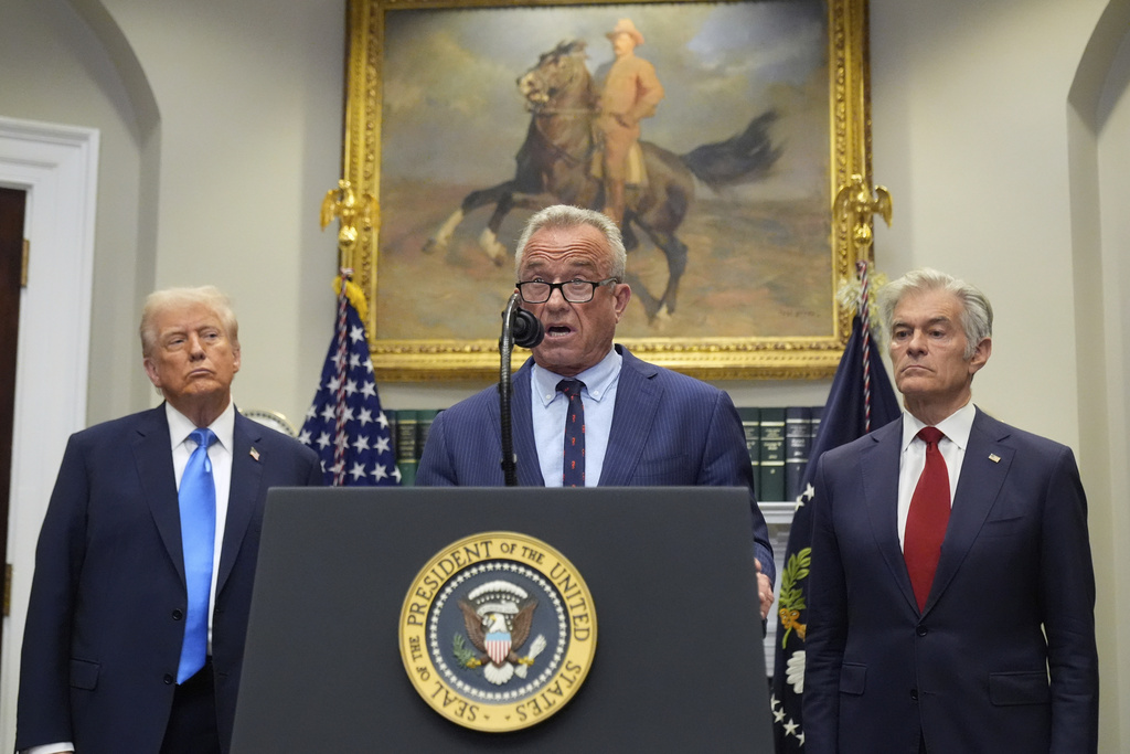 President Donald Trump and Centers for Medicare & Medicaid Services administrator Dr. Mehmet Oz listen as Health and Human Services Secretary Robert F. Kennedy Jr. speaks in the Roosevelt Room of the White House, Monday, Sept. 22, 2025, in Washington. (AP Photo/Mark Schiefelbein)