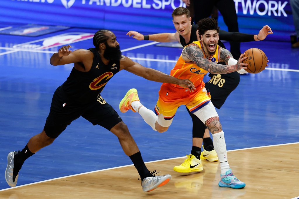 Charlotte Hornets guard LaMelo Ball, front right, drives between Cleveland Cavaliers guards James Harden, left, and Sam Merrill, back right, during the first half of an NBA basketball game in Charlotte, N.C., Friday, Feb. 20, 2026. (AP Photo/Nell Redmond)