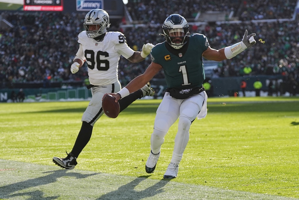 Las Vegas Raiders defensive tackle Jonah Laulu (96) forces Philadelphia Eagles quarterback Jalen Hurts (1) out of bounds during the first half of an NFL football game Sunday, Dec. 14, 2025, in Philadelphia. (AP Photo/Matt Rourke)