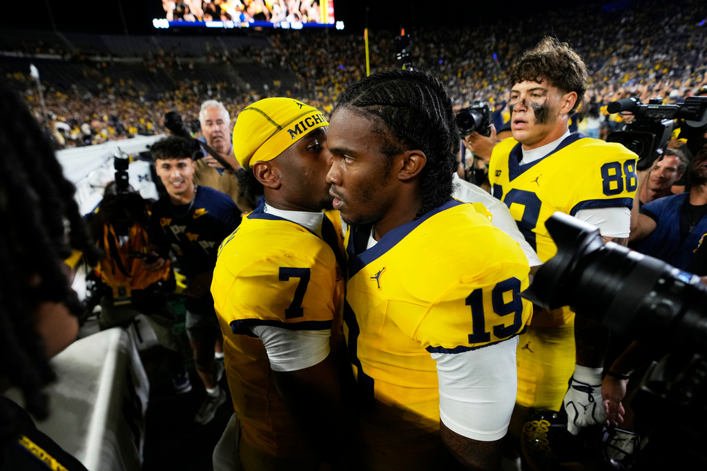 Michigan quarterback Bryce Underwood (19) talks with Chris Bracy (7) after an NCAA college football game against the Western Michigan Saturday, Sept. 5, 2026, in Ann Arbor, Mich. (AP Photo/Paul Sancya)