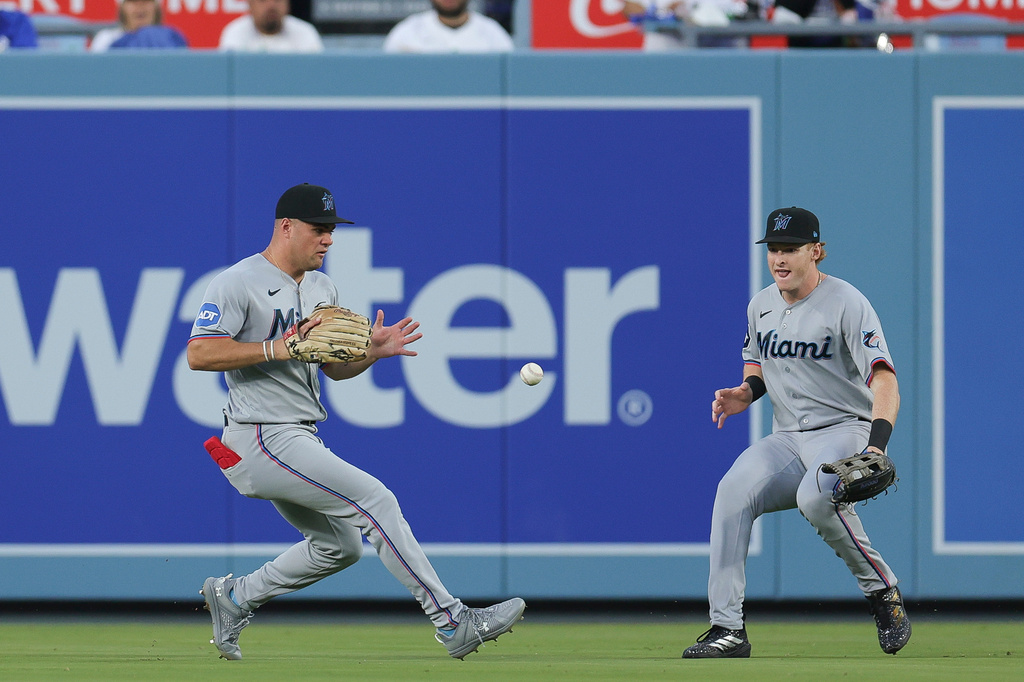 Miami Marlins center fielder Jakob Marsee, left, fields a single hit by Los Angeles Dodgers' Freddie Freeman during the first inning of a baseball game Monday, April 27, 2026, in Los Angeles. (AP Photo/Ryan Sun)