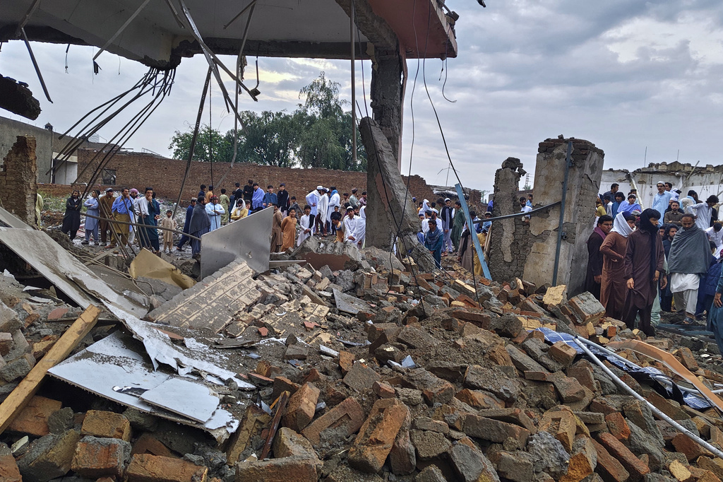 Local residents look at a damaged area of a police station after an overnight deadly bombing in the Bannu district of northwestern Pakistan, Friday, April 3, 2026. (AP Photo/Amaad Khattak)