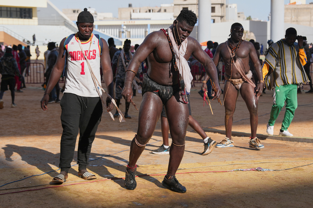 A wrestler performs a traditional dance at a wrestling competition at the national arena in Dakar, Senegal, Sunday, March 29, 2026. (AP Photo/Misper Apawu)