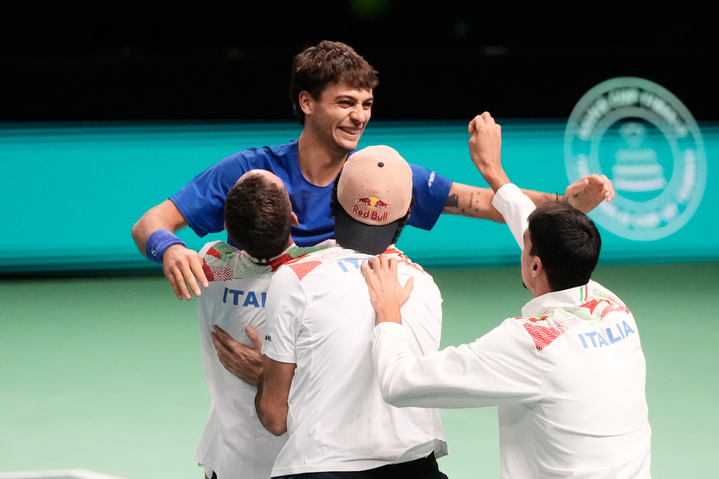 Italy's Flavio Cobolli, top, celebrates with teammates after winning a Davis Cup final singles tennis match against Spain's Jaume Munar, in Bologna, Italy, Sunday, Nov. 23, 2025. (AP Photo/Luca Bruno)