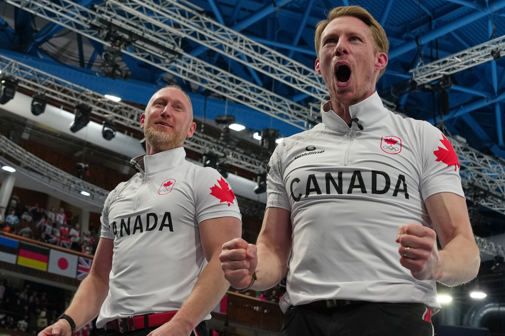 Canada's Brad Jacobs, left, and Marc Kennedy celebrate defeating Britain in a men's curling gold medal match, at the 2026 Winter Olympics, in Cortina d'Ampezzo, Italy, Saturday, Feb. 21, 2026. (AP Photo/Misper Apawu)