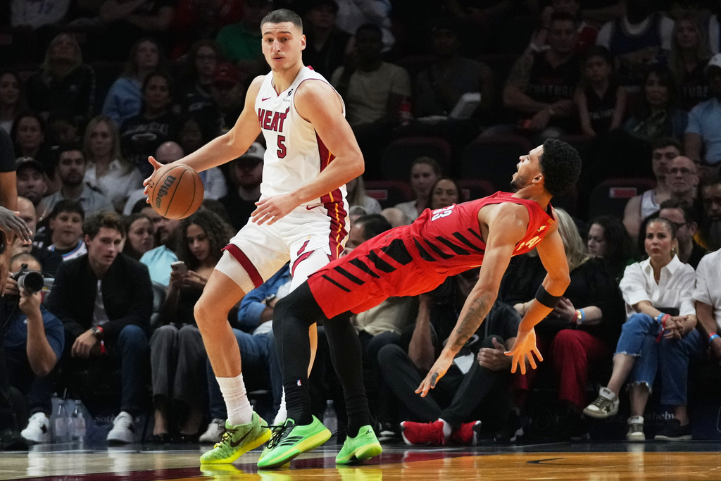 Portland Trail Blazers forward Toumani Camara, right, is fouled by Miami Heat forward Nikola Jovic (5) during the first half of an NBA basketball game, Saturday, Nov. 8, 2025, in Miami. (AP Photo/Lynne Sladky)