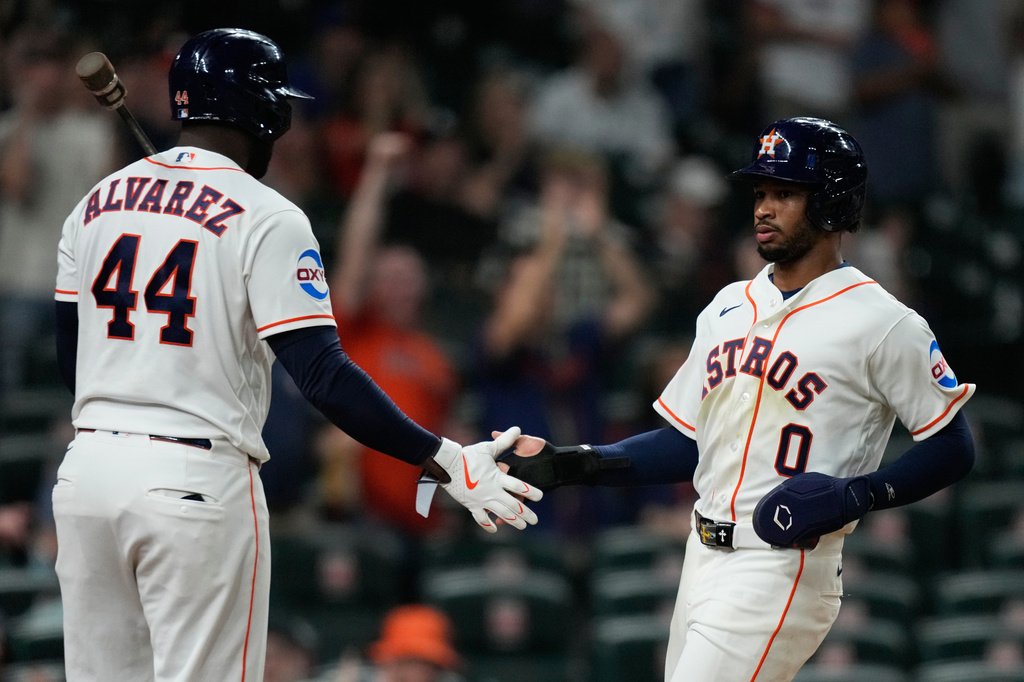 Houston Astros' Brice Matthews (0) celebrates with Yordan Alvarez after scoring during the eighth inning of a baseball game against the Seattle Mariners in Houston, Wednesday, May 13, 2026. (AP Photo/Ashley Landis)