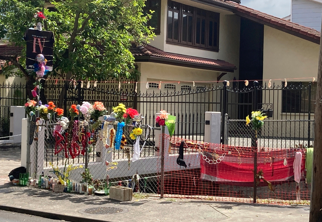 FILE - Floral bouquets, deflated balloons, candles and other items decorate a street memorial by the Kalakaua Canal where Honolulu Police shot and killed 16-year-old Iremamber Sykap during a car chase on Kalakaua Ave., in Honolulu, April 28, 2021. (AP Photo/Jennifer Sinco Kelleher, File)