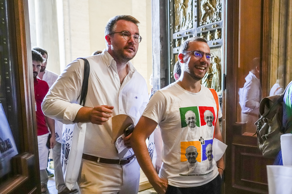 Some of the hundreds of LGBTQ+ Catholics and their families who joined a Holy Year pilgrimage to Rome, celebrating a new level of acceptance in the Catholic Church and crediting Pope Francis for the change, walk through the Holy Door of St. Peter's Basilica at the Vatican, Saturday, Sept. 6, 2025. (AP Photo/Andrew Medichini)
