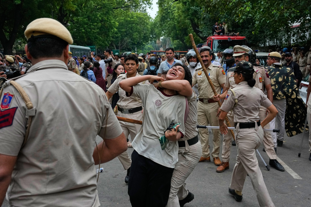 Policewomen detain a supporter of the Cockroach Janta Party as she along with others attempt to march toward India's Parliament, demanding the resignation of the education minister, in New Delhi, India, Monday, July 20, 2026. (AP Photo/Manish Swarup)