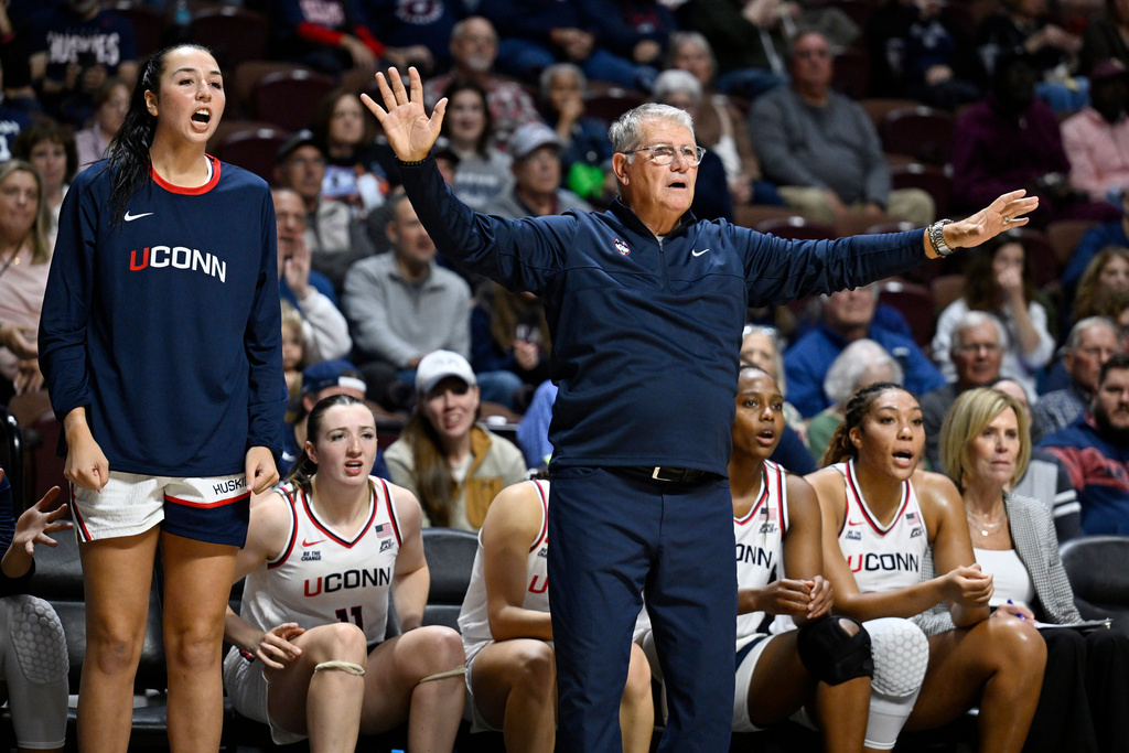 UConn head coach Geno Auriemma gestures as player Caroline Ducharme, left, calls out to their team in the first half of an exhibition NCAA college basketball game against Boston College, Monday, Oct. 13, 2025, in Uncasville, Conn. (AP Photo/Jessica Hill)