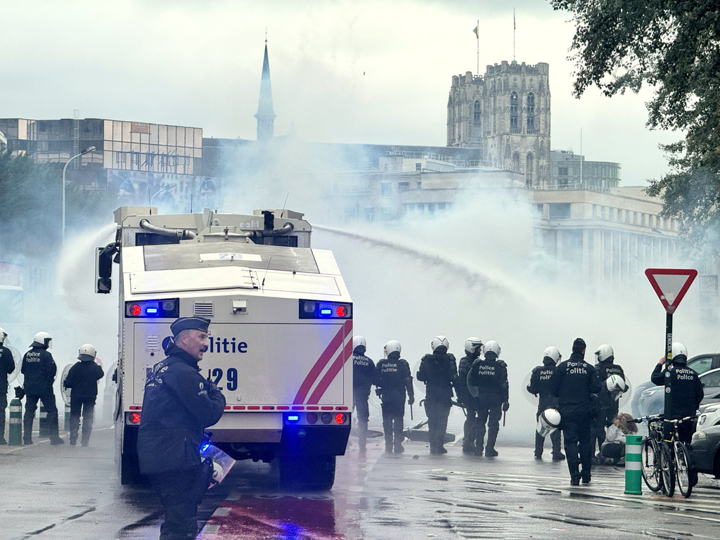 Police use a water cannon against protestors during a demonstration and general strike in Brussels, Tuesday, Oct. 14, 2025. (AP Photo/Sylvain Plazy)
