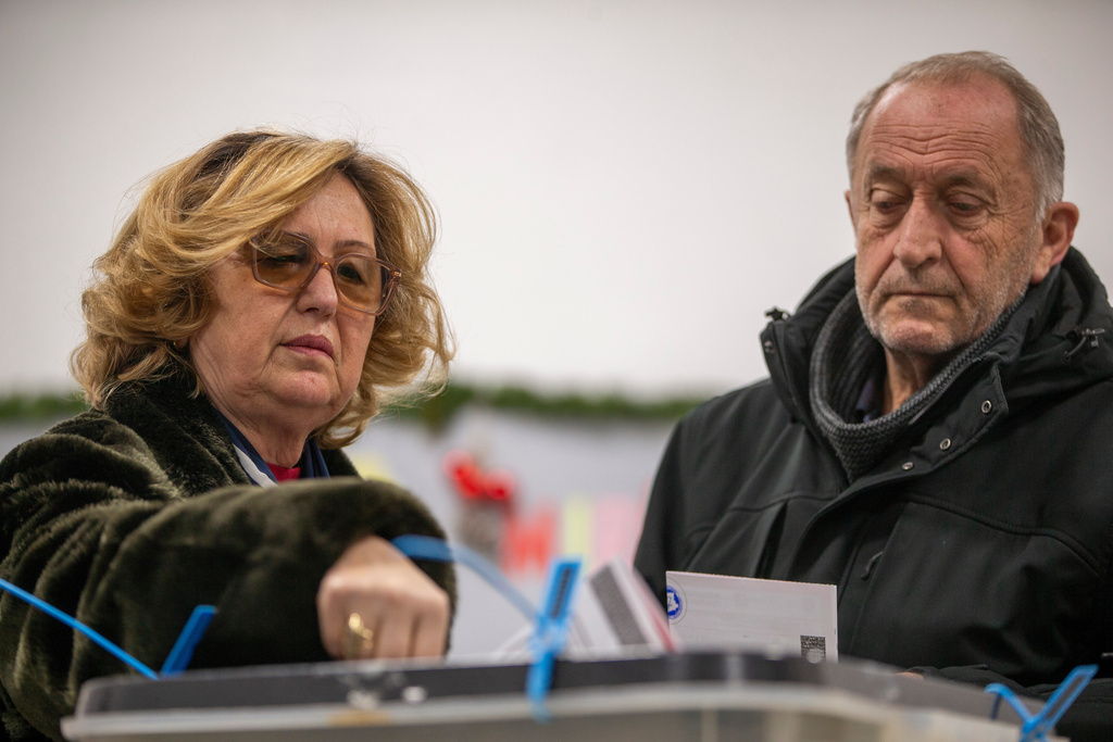 A couple cast their votes in early parliamentary election in Kosovo's capital Pristina, Sunday Dec. 28, 2025. (AP Photo/Visar Kryeziu)