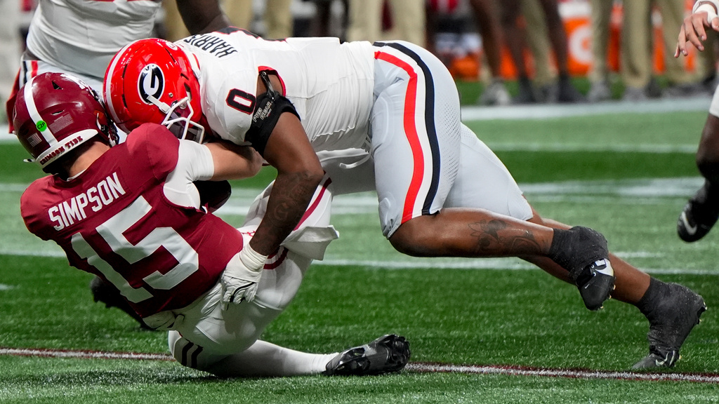 Georgia linebacker Gabe Harris Jr. (0) hits Alabama quarterback Ty Simpson (15) during the first half of a Southeastern Conference championship NCAA college football game, Saturday, Dec. 6, 2025, in Atlanta. (AP Photo/Mike Stewart)