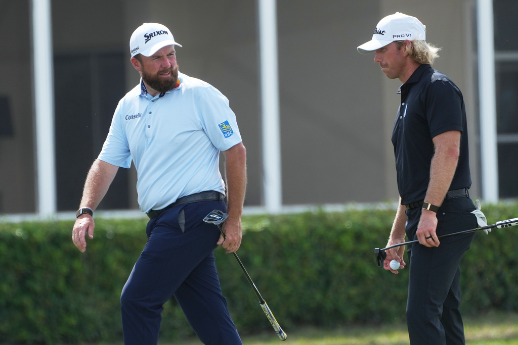 Shane Lowry of Ireland talks to Jimmy Stanger on the 17 green during the third round of the Cognizant Classic golf tournament, Saturday, Feb. 28, 2026, in Palm Beach Gardens, Fla. (AP Photo/Marta Lavandier)
