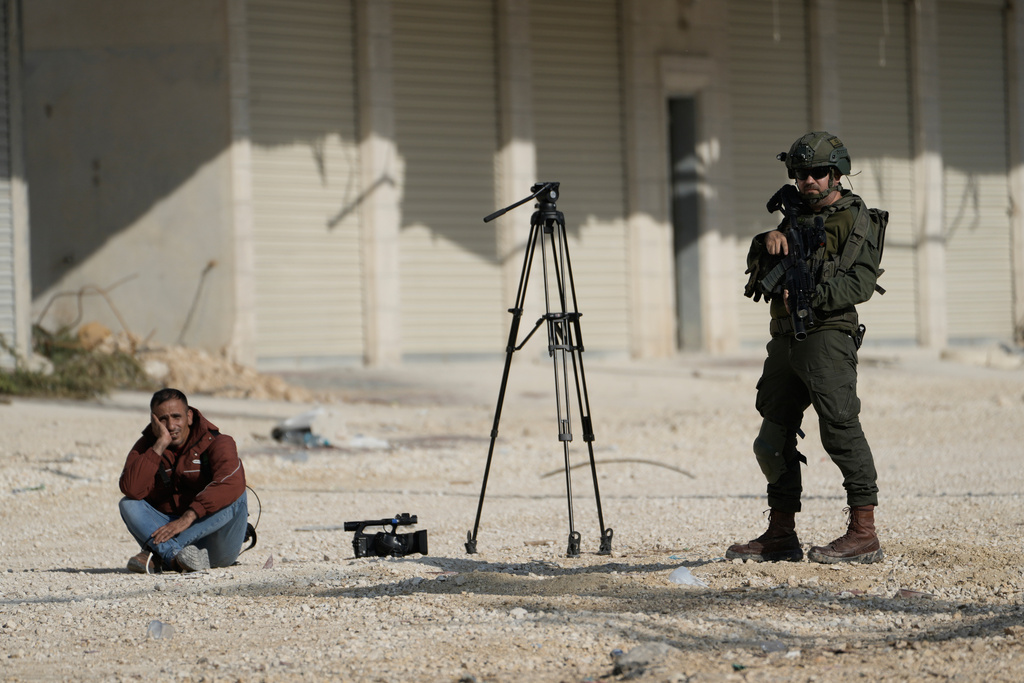 Mahmoud Fawzi, a cameraman for the Jordanian TV channel Roya TV, is detained by Israeli soldiers during a protest by displaced Palestinians calling to return to their houses in the Nur Shams refugee camp, in the West Bank city of Tulkarem, Tuesday, Nov. 18, 2025. (AP Photo/Majdi Mohammed)