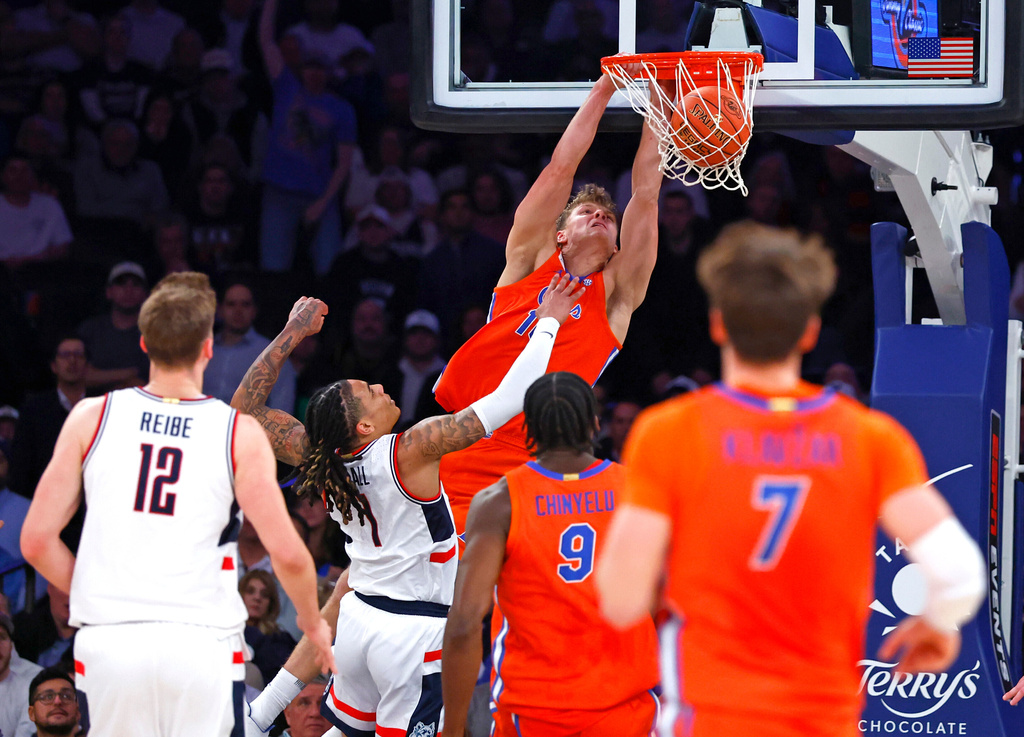 Florida forward Thomas Haugh (10) dunks against UConn guard Solo Ball (1) during the first half of an NCAA basketball game, Tuesday, Dec. 9, 2025, in New York. (AP Photo/Noah K. Murray)