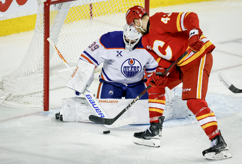 Edmonton Oilers goalie Connor Ingram (39) blocks the net against Calgary Flames' Adam Klapka during the third period of an NHL hockey game in Calgary, Alberta, Saturday, Dec. 27, 2025. (Jeff McIntosh/The Canadian Press via AP)